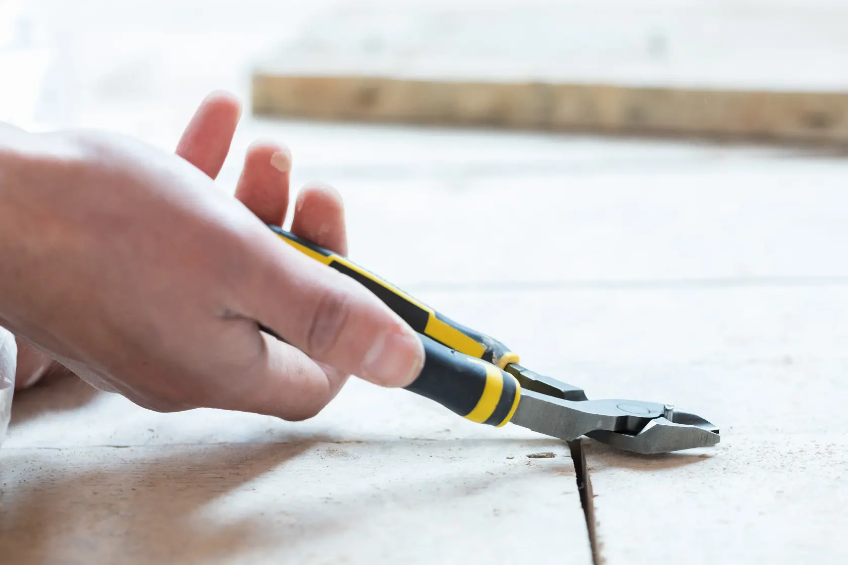 Photo of STANLEY 0-89-860 diagonal cutting pliers with yellow and black grips in use on tile floor.