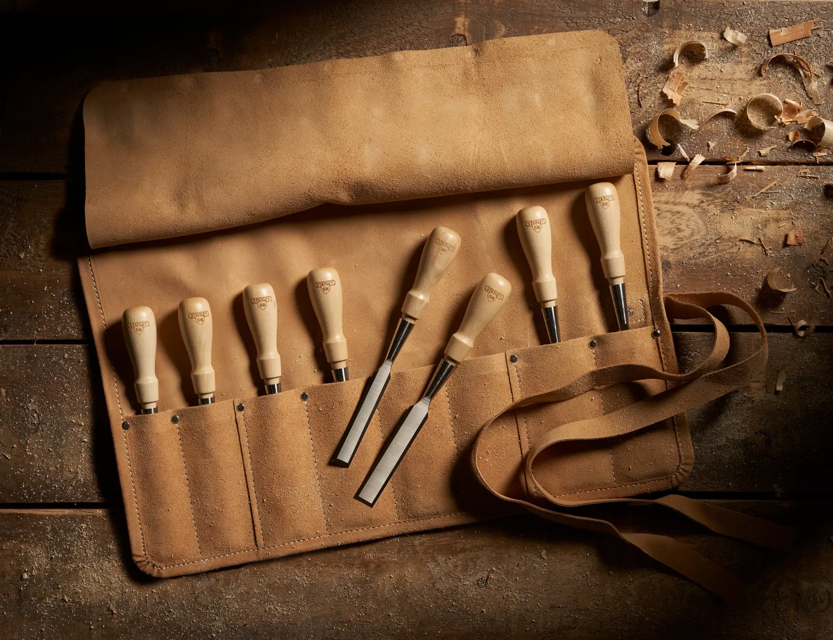 STANLEY 1-16-793 chisel set in tan leather roll, photographed from above on rustic wood.