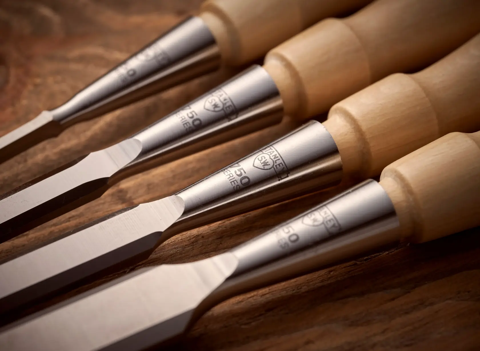 STANLEY 1-16-793 woodworking chisels with wood handles, close-up angle on wooden surface.