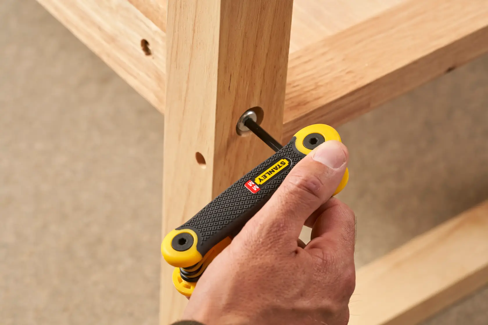 Photo of STANLEY 2-69-264 folding hex key set being used to assemble wooden furniture.