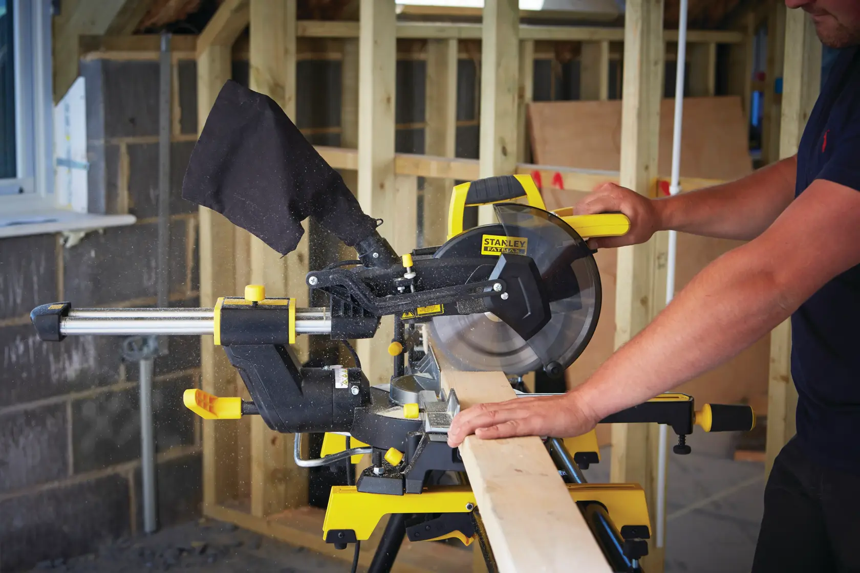 Photo of STANLEY FME721-GB mitre saw in use cutting wood on a construction site.