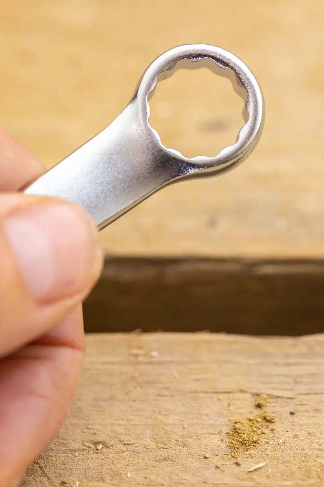 STANLEY FMMT13038-0 box-end wrench in hand, close-up view, photographed on a wooden surface.