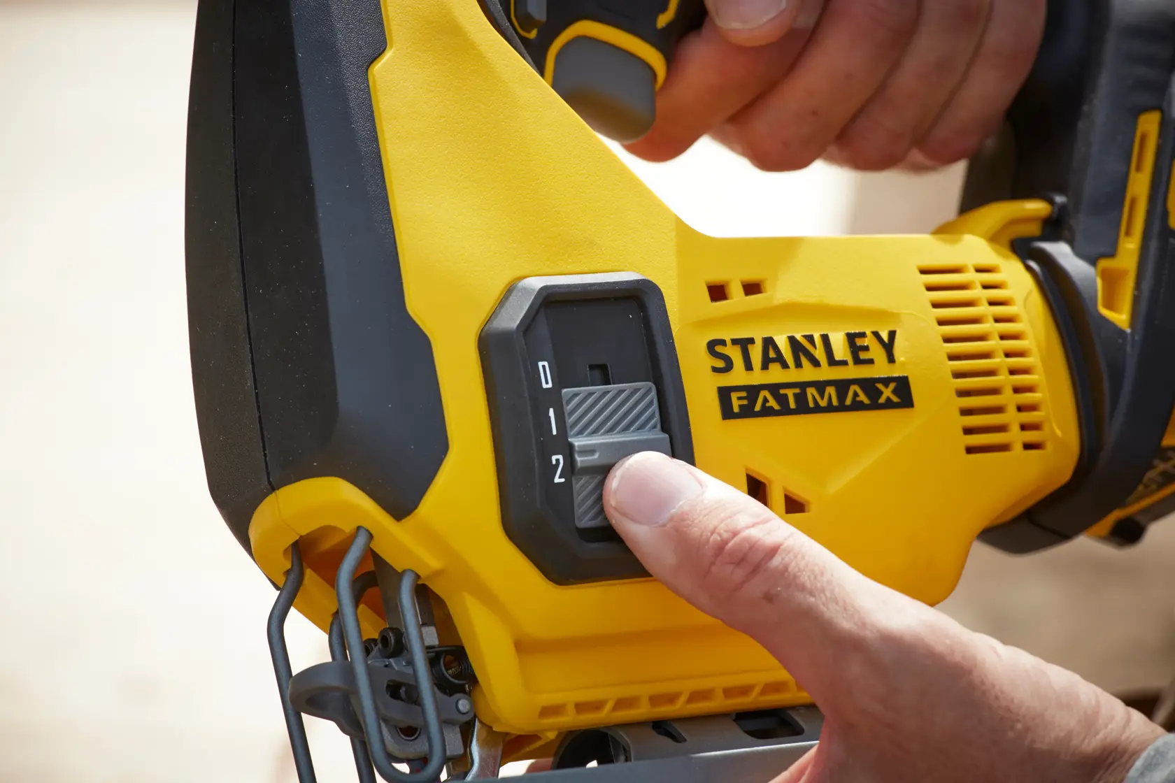 STANLEY SFMCS600M1K jigsaw control switch close-up showing hand adjusting speed.