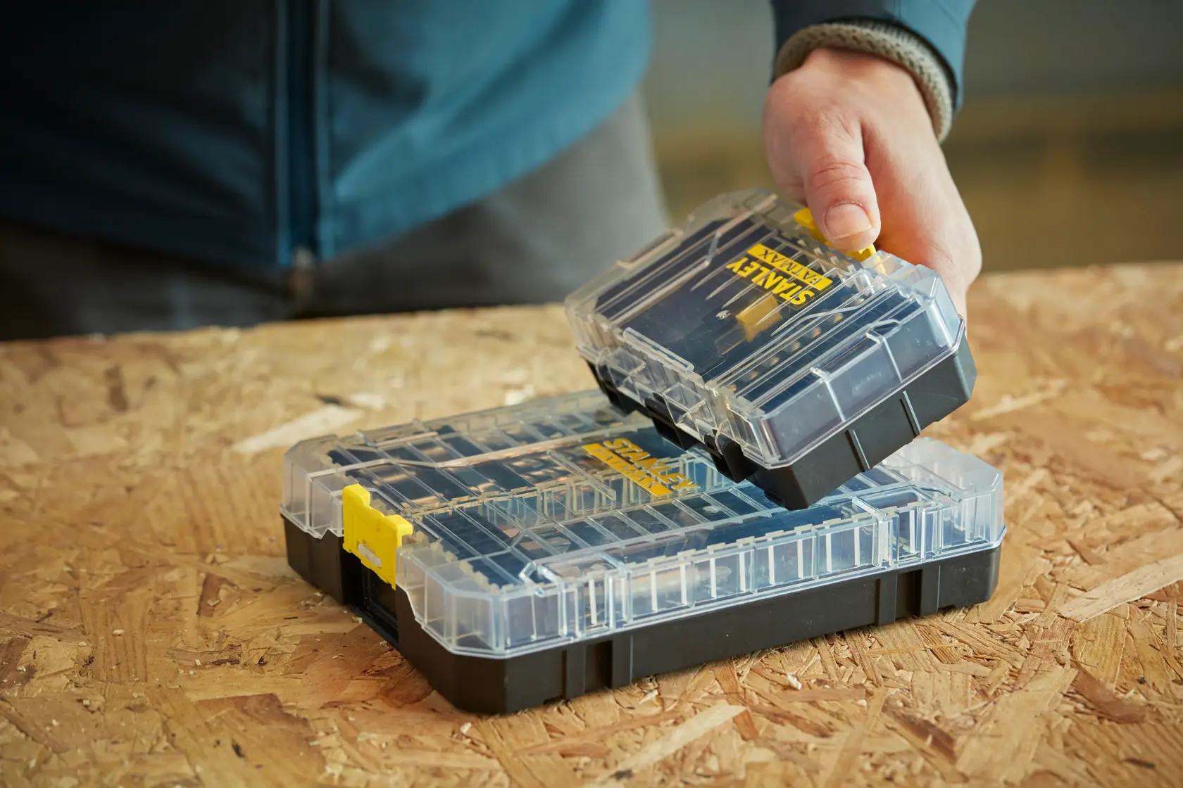STANLEY STA88556 clear plastic organizer box with removable compartment, on wooden surface.