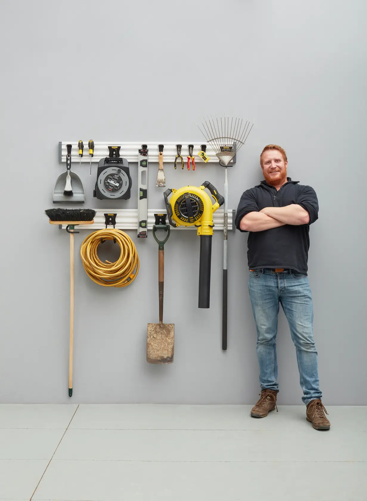 STANLEY STST22000-1 wall-mounted tool organizer with various garden tools and accessories, shown in a garage setting.