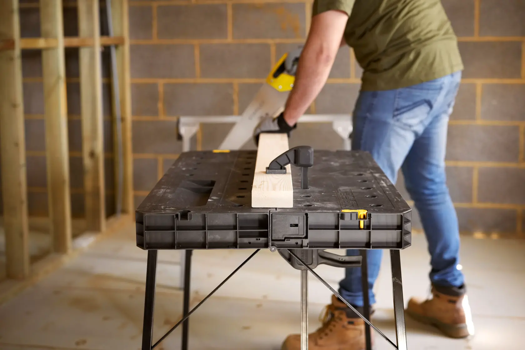 STANLEY STST83492-1 workbench table in use, black plastic with foldable legs, photography from front angle.